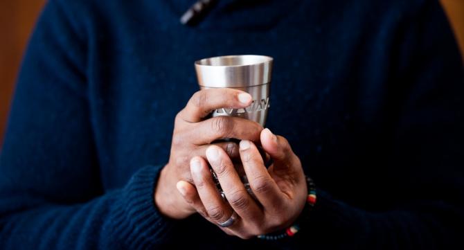 Hands holding kiddush cup